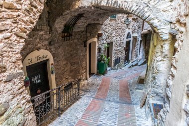 Dolceacqua, İtalya - 06-07-2021: Dolceacqua 'nın tarihi merkezinde kemer ve çiçeklerle birlikte karakteristik küçük sokaklar