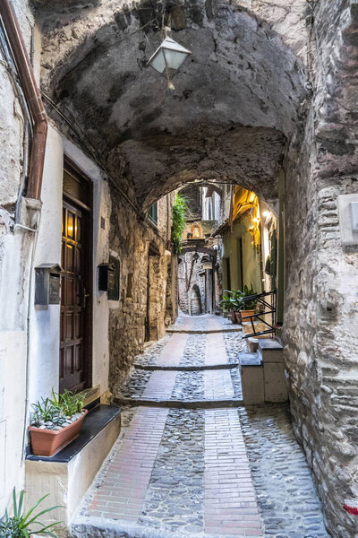 Dolceacqua, Italy - 06-07-2021: Characteristic small streets in the historic center of Dolceacqua with arches and flowers