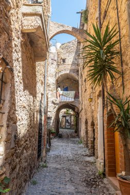 Bussana Vecchia, İtalya - 04-07-2021: Bussana Vecchia 'daki evlere giden antik sokaklar hasar gördü ve depremde bitkiler ve çiçekler meydana geldi