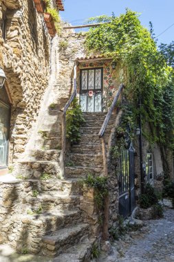 Bussana Vecchia, İtalya - 04-07-2021: Bussana Vecchia 'daki evlere giden antik sokaklar hasar gördü ve depremde bitkiler ve çiçekler meydana geldi