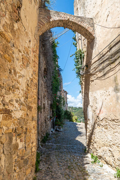 Bussana Vecchia, Italy - 04-07-2021: Ancient streets to houses in Bussana Vecchia damaged and earthquake with plants and flowers