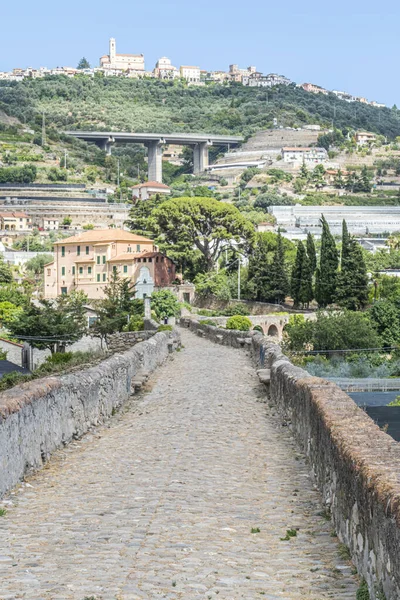 Taggia 'daki antik Roma köprüsünün arka planında Castellaro var.