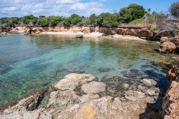 Kristal berrak suyla güzel bir sahil ve Sicilya Sireni 'nin arka planında doğal bir kaya kemeri.