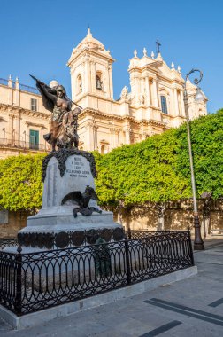 Noto, İtalya - 09-15-2022: Arkaplanda Duomo ile birlikte Noto 'nun tarihi merkezinde güzel bir anıt