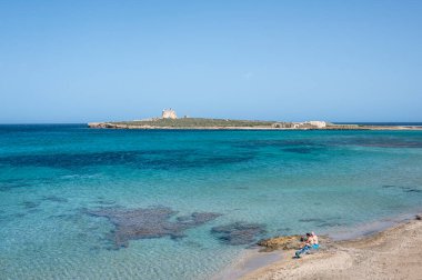 Portopalo, İtalya: 09-15-2022: Akdeniz ve İyon denizlerinin birleştiği Capo Passero adasının önündeki Portopalo plajı