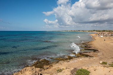 Portopalo di Capopassero 'da kum, turkuaz ve yeşil su ve kum tepeleri olan güzel bir sahil.