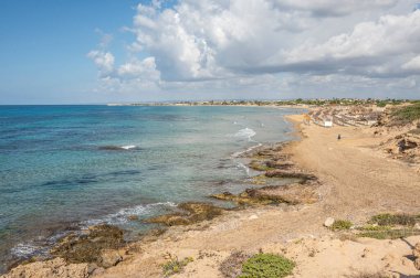 Portopalo di Capopassero 'da kum, turkuaz ve yeşil su ve kum tepeleri olan güzel bir sahil.