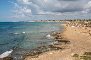 Portopalo di Capopassero 'da kum, turkuaz ve yeşil su ve kum tepeleri olan güzel bir sahil.