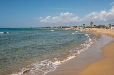 Portopalo di Capopassero 'da kum, turkuaz ve yeşil su ve kum tepeleri olan güzel bir sahil.