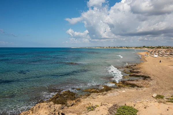 Beautiful beach with sand, turquoise and green water and dunes in Portopalo di Capopassero