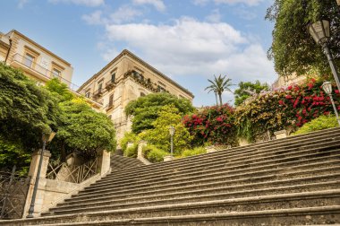 Modica, İtalya: 09-21-2022: Birçok bitki ve renkli çiçekli güzel merdiven S. Giorgio di Modica Katedrali 'ne çıkıyor.