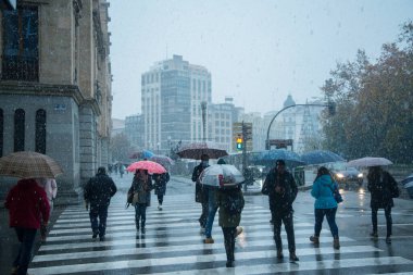 Valladolid, İspanya - 23 Kasım 2021: Valladolid İspanya 'da kar yağarken insanlar karşıya geçiyor