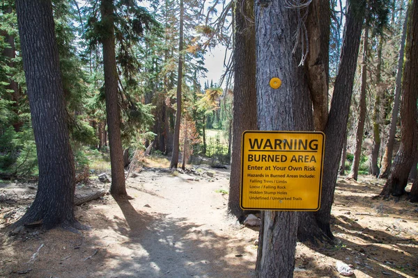 In the aftermath of the Dixie Fire sign warns hikers on the Kings Creek Falls trail to be careful of debris and hazards - Lassen Volcanic National Park.