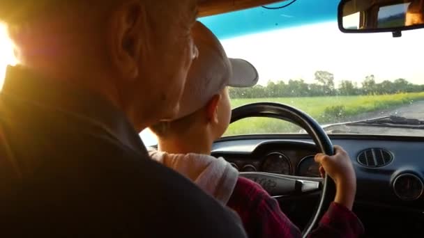 Dziadek Uczy Letniego Chłopca Prowadzić Samochód Chłopiec Siedzi Ramionach Dziadków — Wideo stockowe