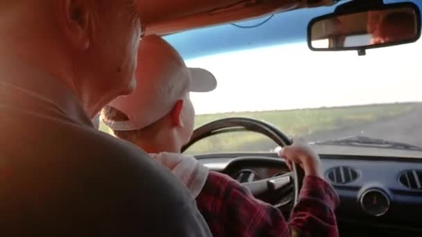 Grootvader Leert Kleinzoon Autorijden Het Kind Zit Zijn Handen Draait — Stockvideo