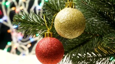 Kırmızı ve altın bir top bir Noel ağacında asılı duruyor. Arka planda Noel ışıkları var. 2023 yılına ve Noel 'e hoş geldiniz. Yeni Yıl Dekorasyonu