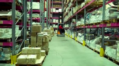 Kharkiv, Ukrayna - 3 Şubat 2022: Büyük bir depoda rafların arasında bir forklift kamyonu geziniyor. Rafın kenarlarında paketlenmiş mallar var. Stokta lojistik