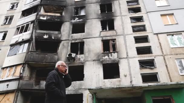 2022年10月3日 乌克兰哈尔科夫 一名老人站在一座乌克兰城市的多层公寓楼附近 该公寓楼在俄罗斯炮击后被烧毁 俄罗斯袭击了乌克兰 — 图库视频影像
