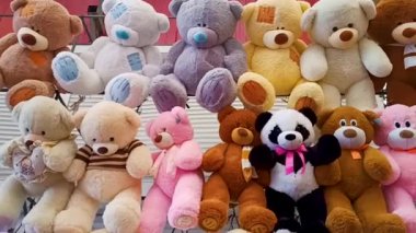 Birçok renkli pelüş oyuncak büyük ayılar vitrine asılır. Panorama. Tatiller için hediyeler
