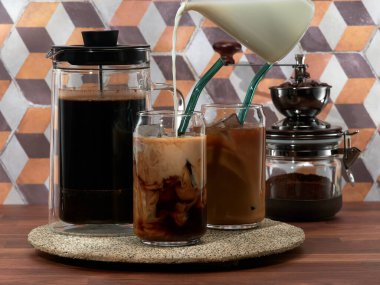 Making cold brew coffee with milk in a french press, also known as a coffee press, or coffee plunger