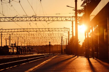 Tren peronu gün batımında. Terk edilmiş bir tren istasyonu. Gün batımında güneşin güzel altın ışığı. trenle yolculuk zamanı