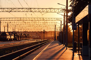 Tren peronu gün batımında. Terk edilmiş bir tren istasyonu. Gün batımında güneşin güzel altın ışığı. trenle yolculuk zamanı