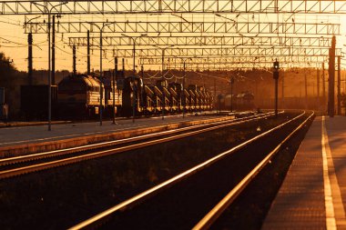 Tren peronu gün batımında. Terk edilmiş bir tren istasyonu. Gün batımında güneşin güzel altın ışığı. trenle yolculuk zamanı