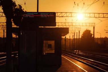 Tren peronu gün batımında. Terk edilmiş bir tren istasyonu. Gün batımında güneşin güzel altın ışığı. trenle yolculuk zamanı