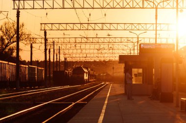 Tren peronu gün batımında. Terk edilmiş bir tren istasyonu. Gün batımında güneşin güzel altın ışığı. trenle yolculuk zamanı