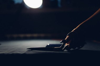 Terzi kumaşı makasla keser. Kişisel standartlara göre giysi üretimi elle yapılır. Moda endüstrisi. Moda tasarımcısı evde çalışıyor.