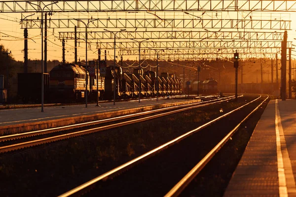 Tren peronu gün batımında. Terk edilmiş bir tren istasyonu. Gün batımında güneşin güzel altın ışığı. trenle yolculuk zamanı