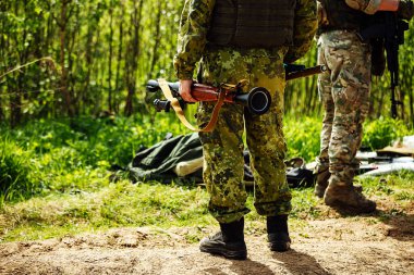 Bir asker roket atar. Askeri eğitim alanında roket atarla eğitim atışı. Bir roket mermisi bir askerin elinde silahtan fırlıyor.