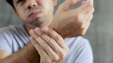 Adam bileğine acıdan masaj yaptı.