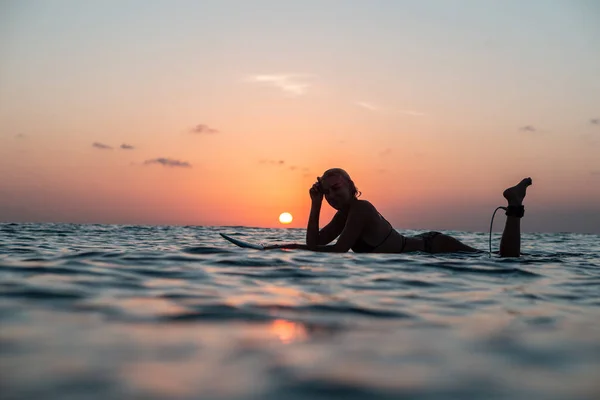 美しい体を持つサーファーの女の子の肖像 バリ島のカラフルな夕日の時間で海のサーフボードに — ストック写真