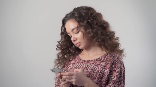 Грустная расстроенная девушка с телефоном в руках печатает сообщение в вестнике — стоковое видео