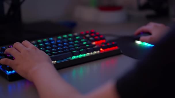 Гравець в кіберспорт грає в ігри на ігровій клавіатурі і миші з підсвічуванням RGB — стокове відео