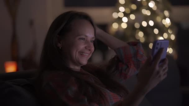 En kvinna som sitter hemma på kvällen kommunicerar med vänner via videolänk — Stockvideo