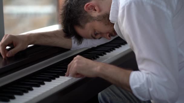 Der Pianist Komponist, den die Muse in Depressionen zurückließ, spielt Klavier — Stockvideo