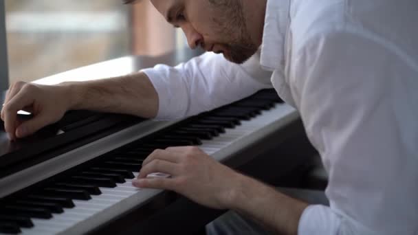 De componist-pianist improviseert, componeert muziek en speelt piano. — Stockvideo
