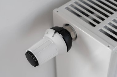 Merkezi ısıtma radyatörünü ayarlamak için kullanılan beyaz termostat odadaki maksimum sıcaklık bakım moduna ayarlandı