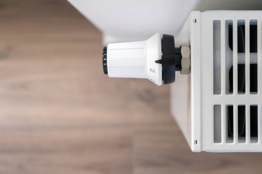 Merkezi ısıtma radyatörünün sıcaklığını ayarlamak için kullanılan beyaz termostat kapalı konuma ayarlandı.