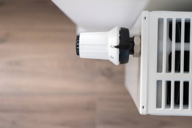 Merkezi ısıtma radyatörünü ayarlamak için kullanılan beyaz termostat ekonomik asgari sıcaklık moduna ayarlandı
