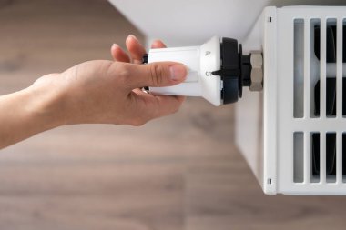 Merkezi ısıtma radyatörünü ayarlamak için kullanılan beyaz termostat odadaki maksimum sıcaklık bakım moduna ayarlandı