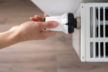 Merkezi ısıtma radyatörünü ayarlamak için kullanılan beyaz termostat odadaki sıcaklığı korumak için orta ekonomik modda ayarlanır