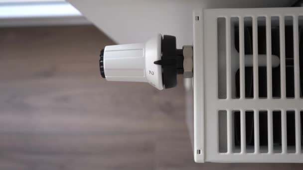 A nő a fűtési radiátor termosztátját közepes gazdaságosságú üzemmódra állítja — Stock videók