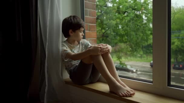 Een Droevige Verlaten Jongen Zit Alleen Thuis Bij Het Raam — Stockvideo