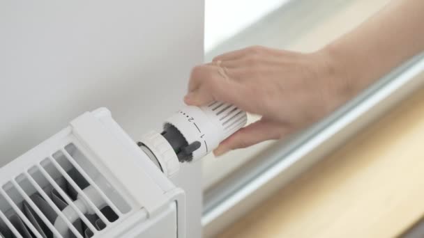 该妇女转动散热器的恒温阀调整器 以最大限度地提高室内加热器的温度 在寒冷天气和严寒天气下给公寓供暖 — 图库视频影像