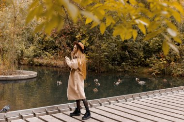 Sonbaharda parkta şapkalı ve sonbahar elbiseli bir kadın. Metin için boş alan