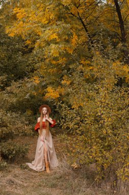Ekim 'de sonbahar ormanında güzel sonbahar kıyafetleri içinde bir kadın. Metin için boş alan. sonbahar günlüğü
