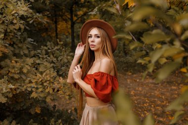 Sonbahar arka planında sonbahar makyajı olan kahverengi şapkalı bir manken. Yakın plan. Sonbaharda güzellik ve moda